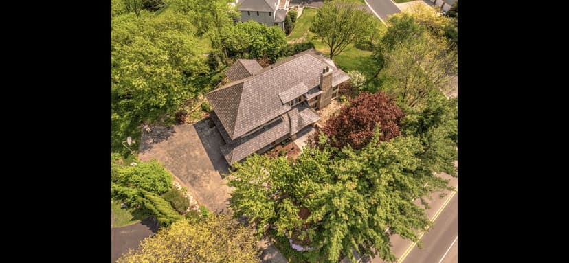 Aerial view of a beautiful home surrounded by lush greenery and landscaped garden.